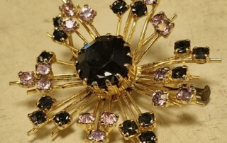 Jolie broche dorée et incrustations noires et roses