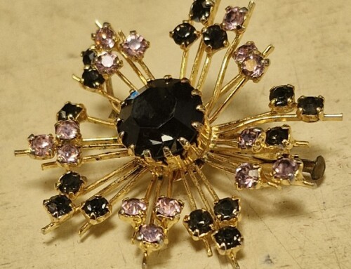 Jolie broche dorée et incrustations noires et roses